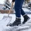 Person shoveling snow in winter wearing JHB08 heated winter boots