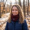 JHN02 Heated Neck Warmer – Autumn Forest Woman wearing JHN02 heated neck warmer with navy puffer jacket in autumn forest scene