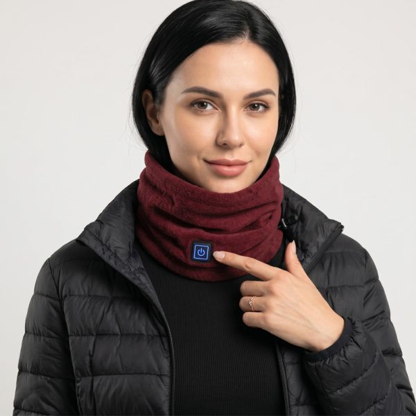 JHN02 Heated Neck Warmer – Model Dark Hair Woman wearing JHN02 heated neck warmer with black puffer jacket, finger pressing power button with blue LED